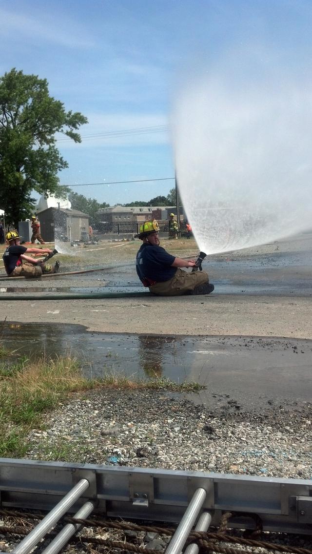 Firefighters use fog patterns to help reduce the radiant heat from the fully-involved building.