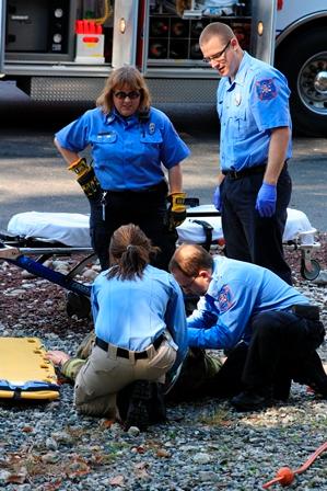 An EMS crew practices assessing and providing care to the &quot;patient&quot; after being extricated from a vehicle during a recent Open House.