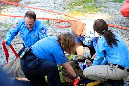 An EMS crew practices assessing and providing care to the &quot;patient&quot; after being extricated from a vehicle during a recent Open House.